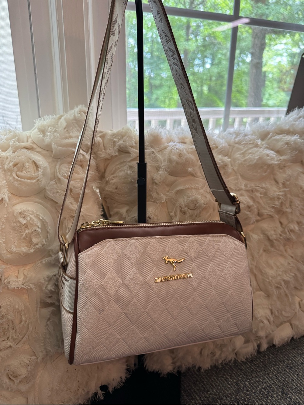 White Quilted Crossbody Bag with Brown Trim and Gold Kangaroo Accent